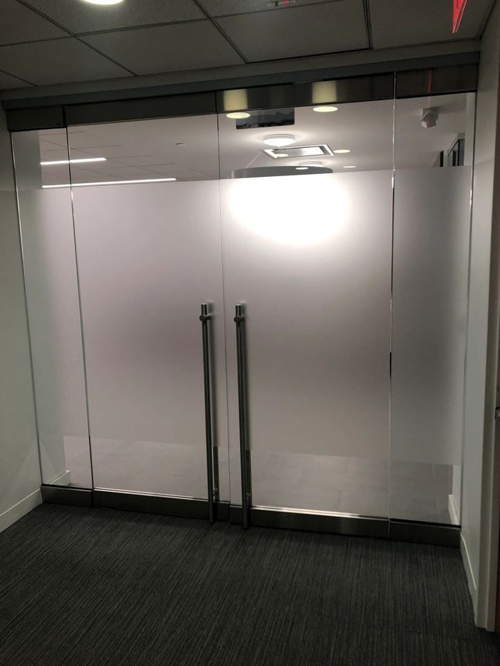 A glass door with two handles and one handle on the side.